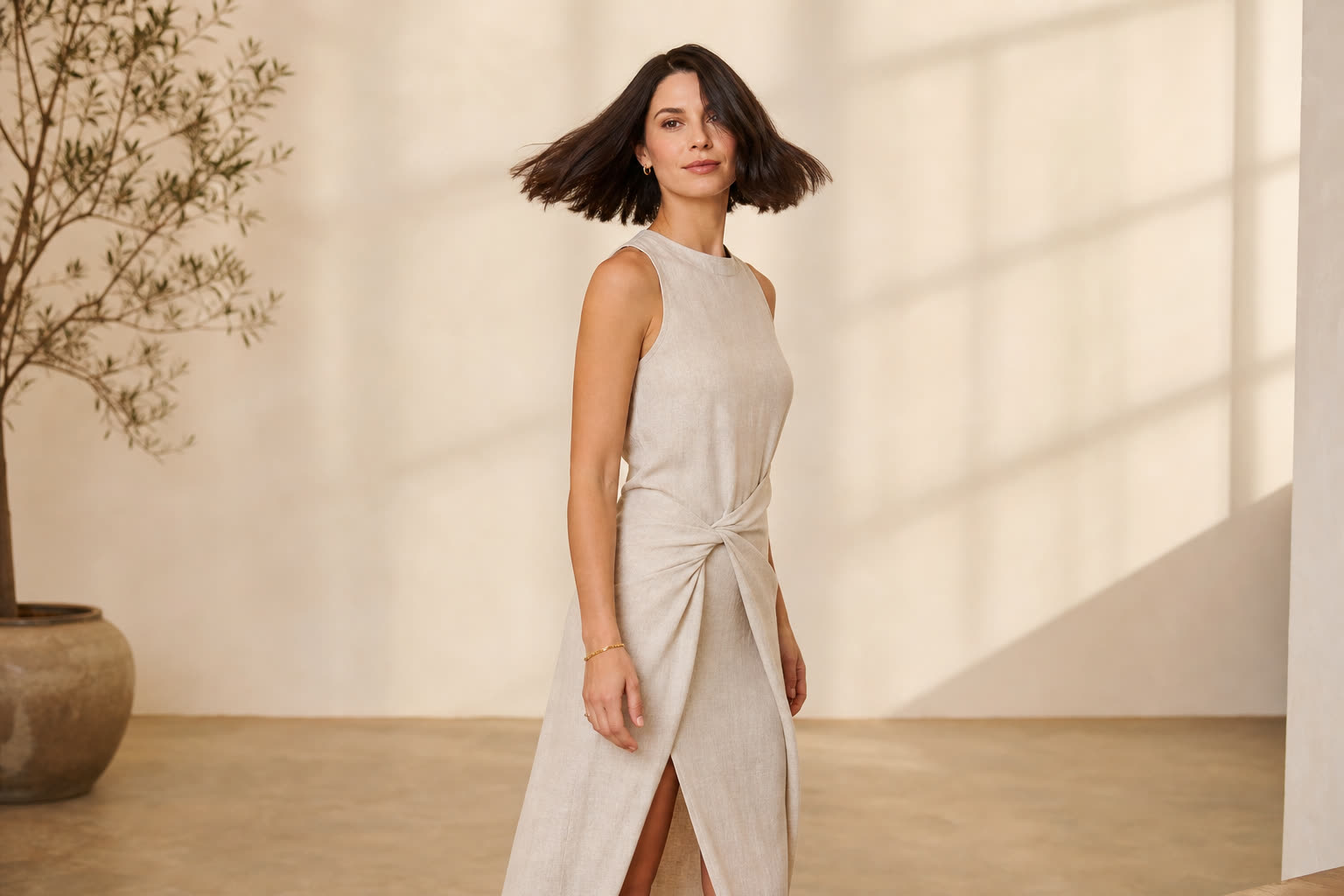 A slender woman in her 30s with a glossy dark bob catching the light as she turns