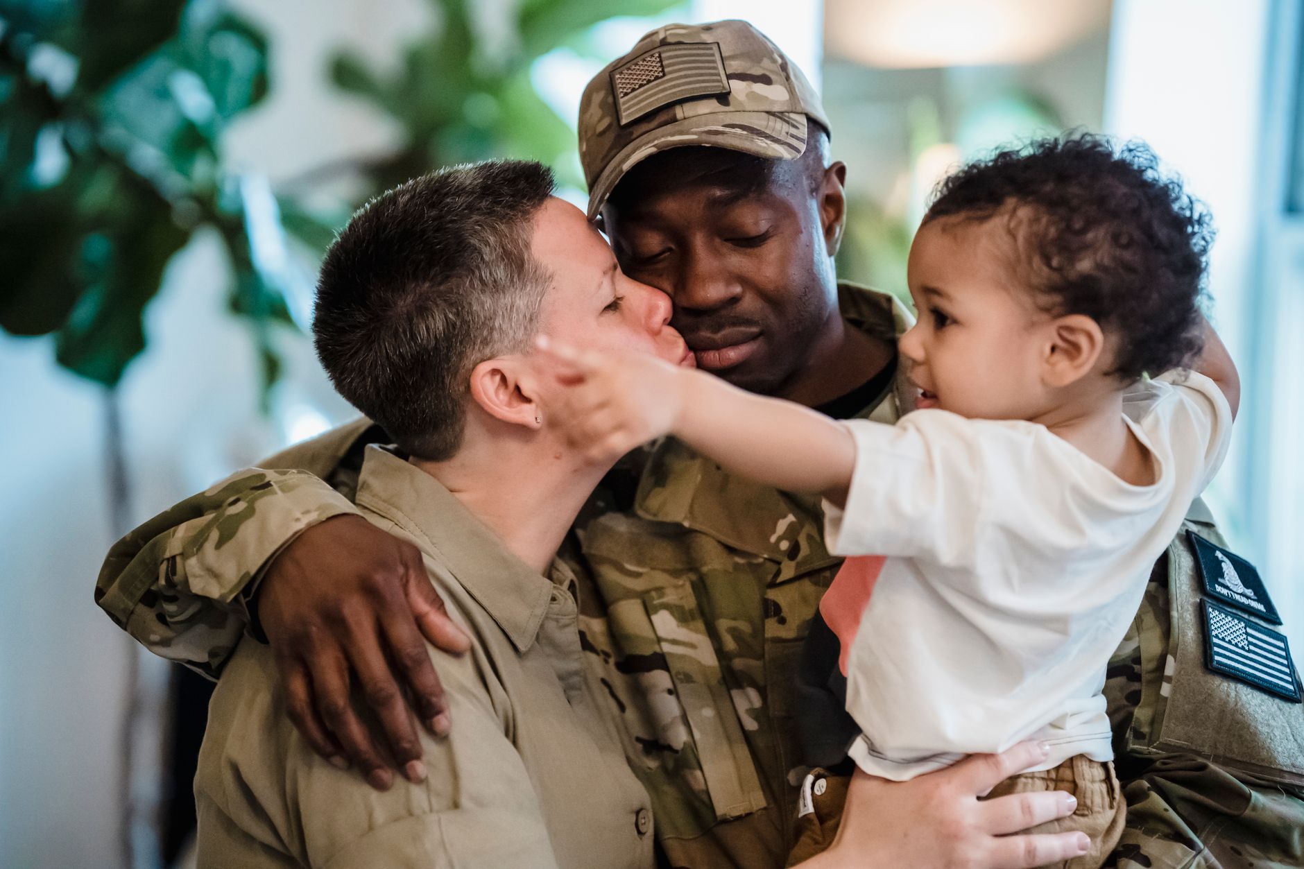 Heartwarming moment of a soldier's homecoming, embraced by family indoors.