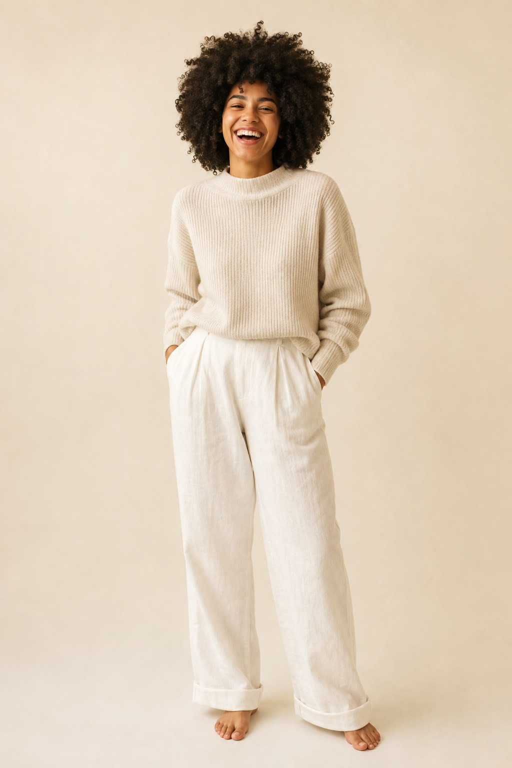 A woman with voluminous coily hair laughing warmly toward the camera