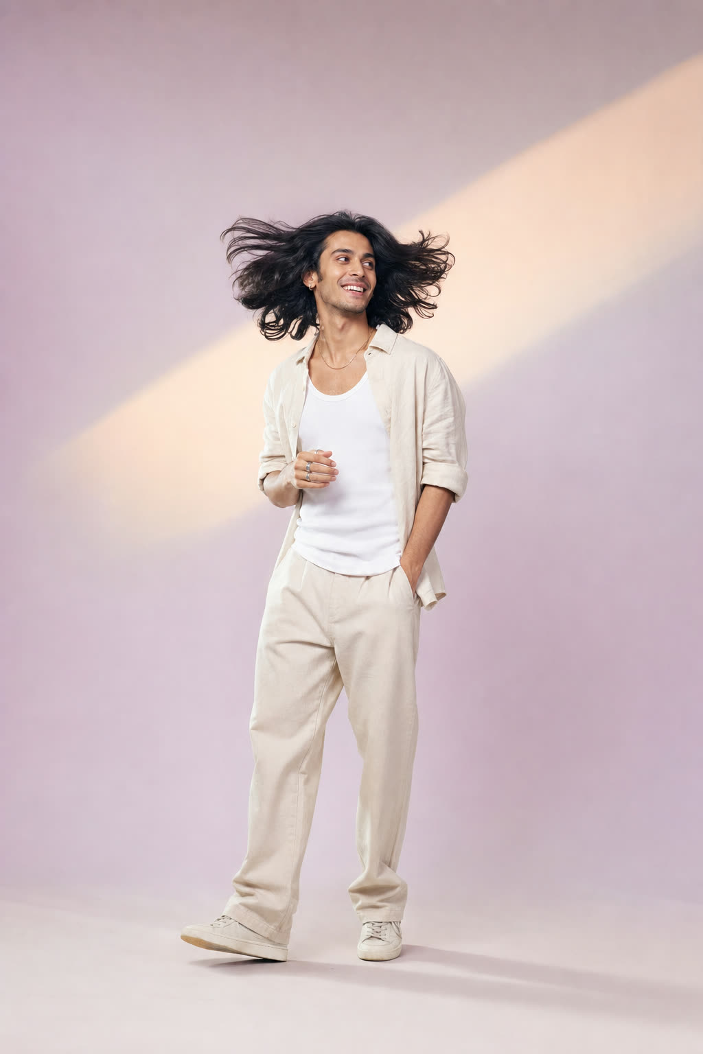 Backlit by bright window light, a person swishes thick, glossy hair mid-turn, caught laughing