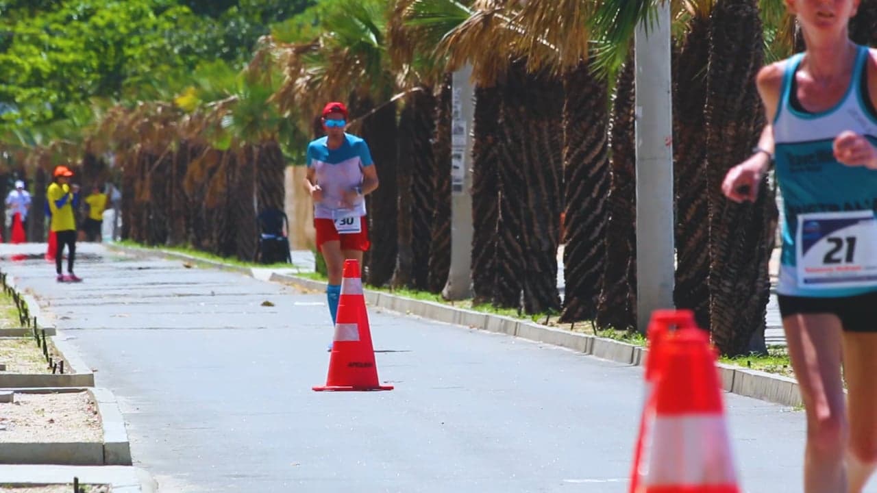 Runners moving down a sunlit street during a road race