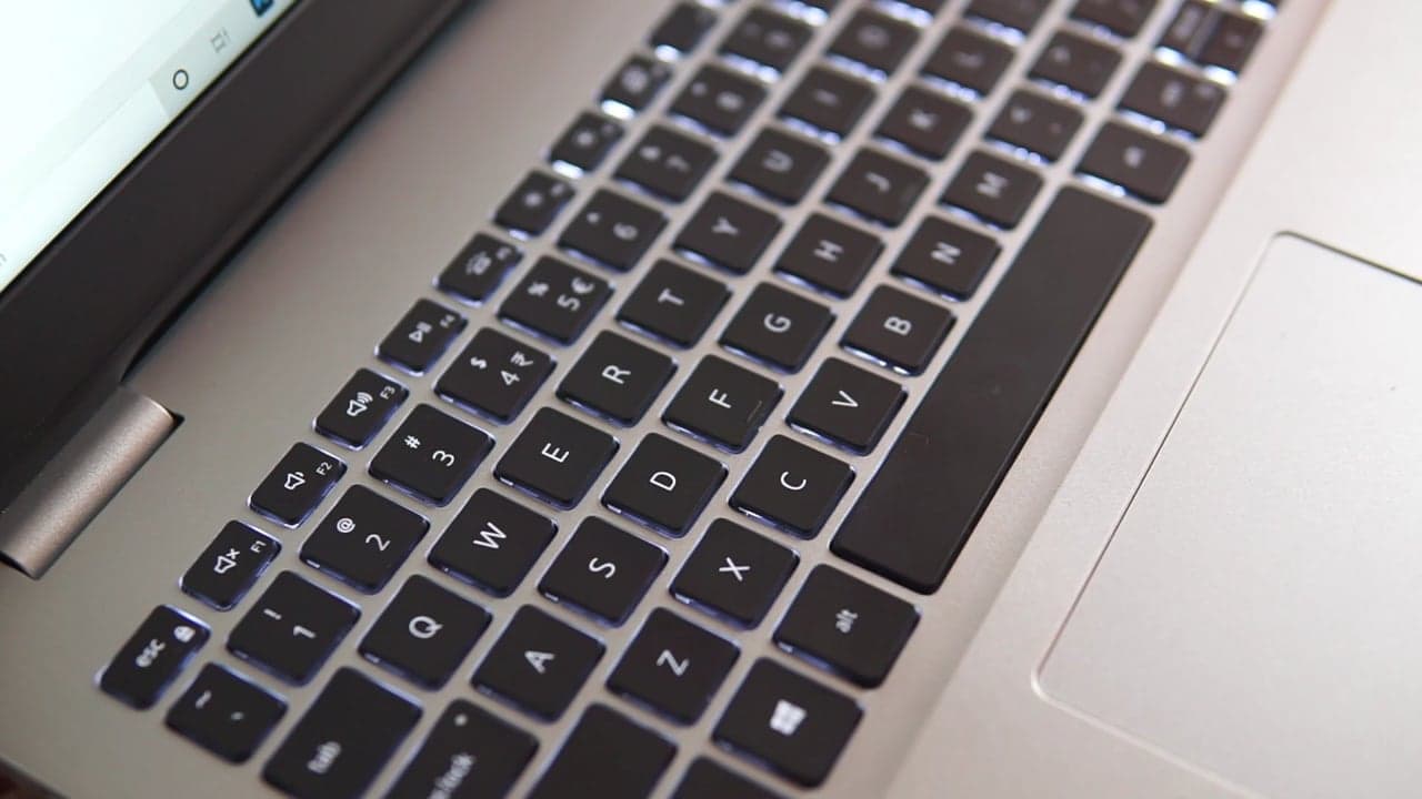 A calm home desk in daylight, a laptop open, a mug steaming beside it