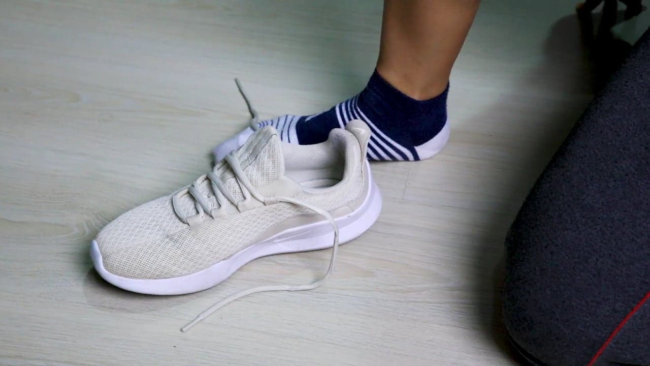 Close footage of running shoes being laced and taking the first steps out the door