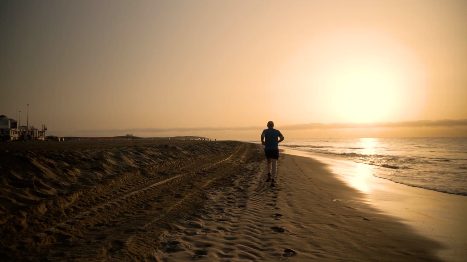 A runner moving along a trail at sunrise