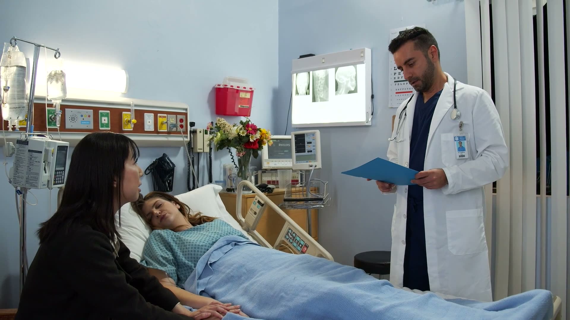 A physician at a bedside, updating a patient on their condition